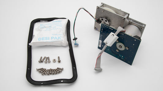 A small electronic device accompanied by screws and a bag, showcasing its compact design and essential components.