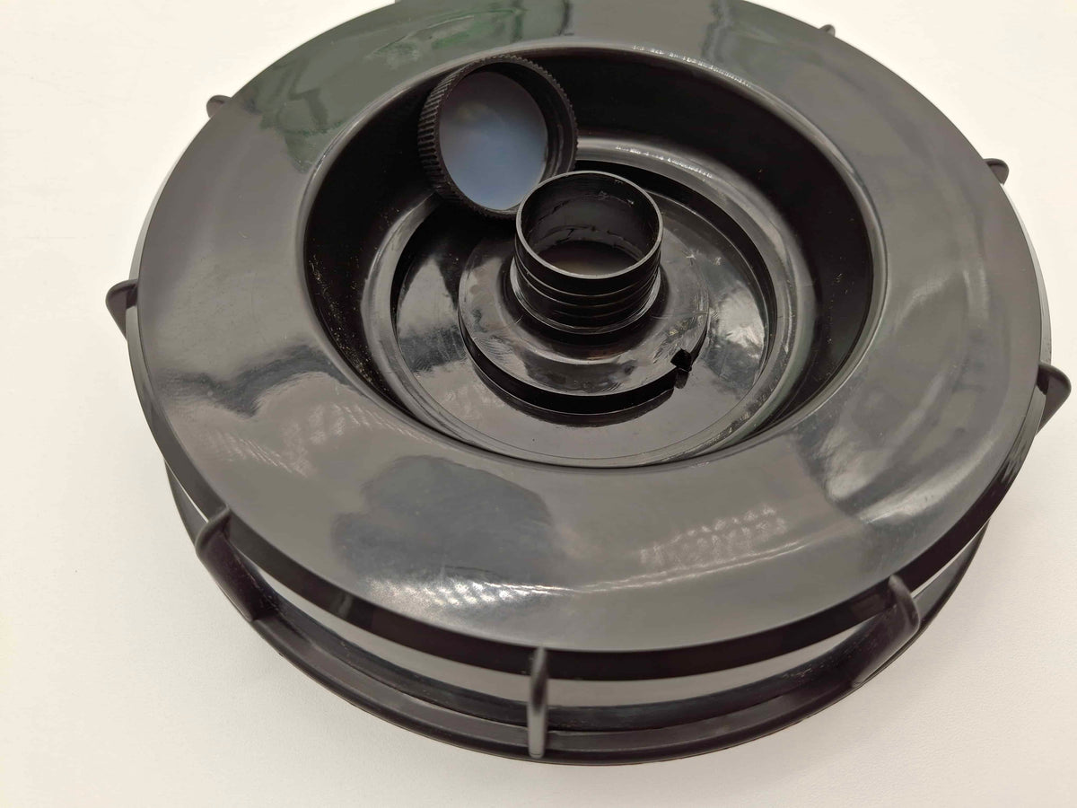 A black plastic circular component with a threaded center opening and a small detached cap, photographed on a plain white background.