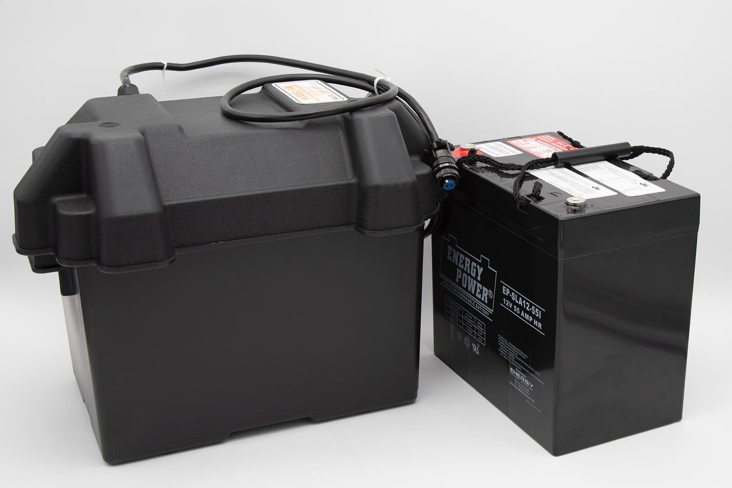 A black battery box alongside a black battery, both positioned on a neutral background, showcasing their sleek design.