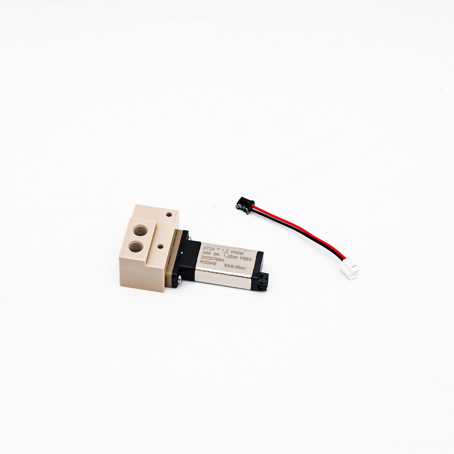 A small industrial solenoid valve or sensor component with a beige plastic housing, black metal body, printed technical label, and a short red-and-black wire lead with a white connector, photographed on a clean white background.