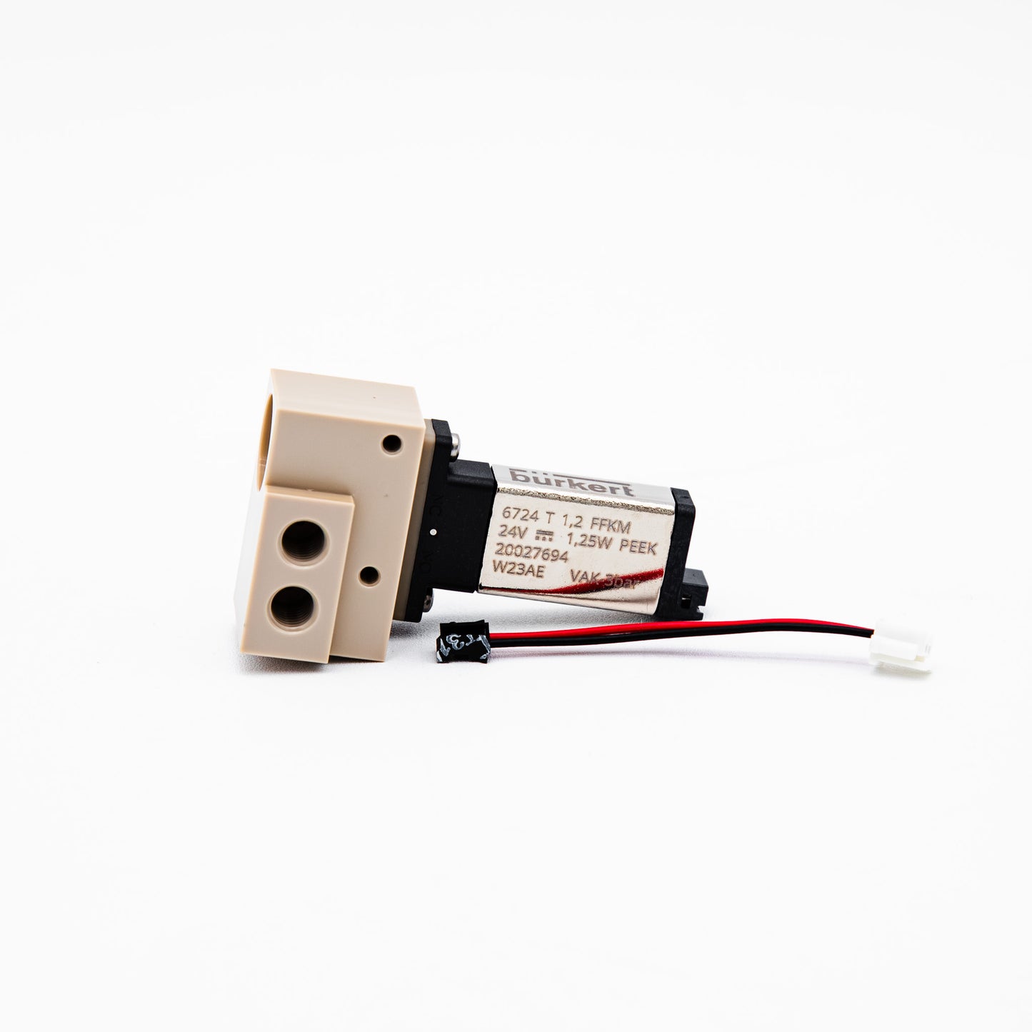 A small industrial solenoid valve actuator with a beige plastic body, black housing, and attached red and black wires, photographed on a clean white background.