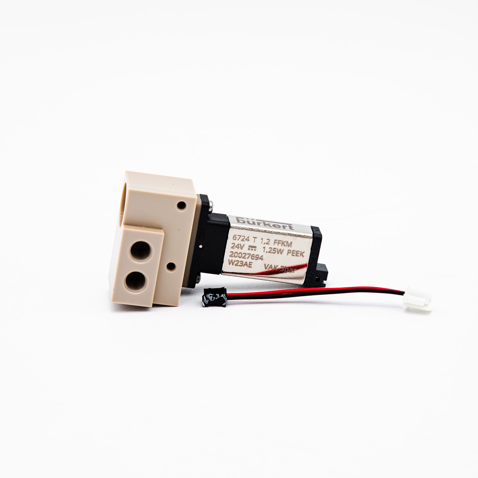 A small industrial solenoid valve actuator with a beige plastic body, black housing, and attached red and black wires, photographed on a clean white background.