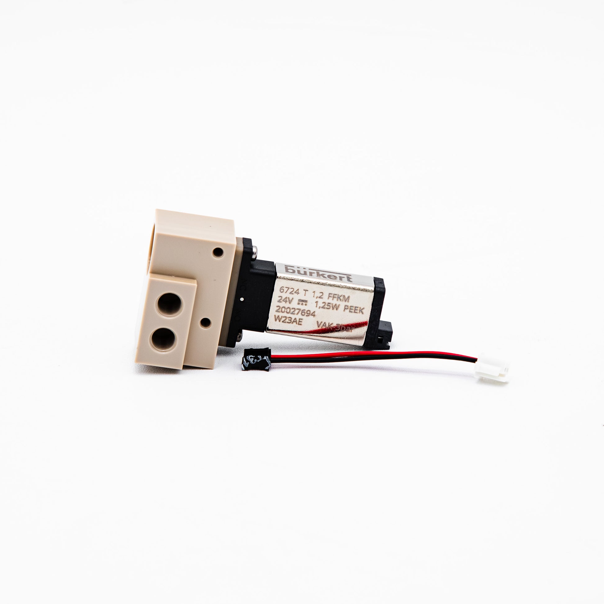 A small industrial solenoid valve actuator with a beige plastic body, black motor housing, and attached red and black wires, photographed on a white background.