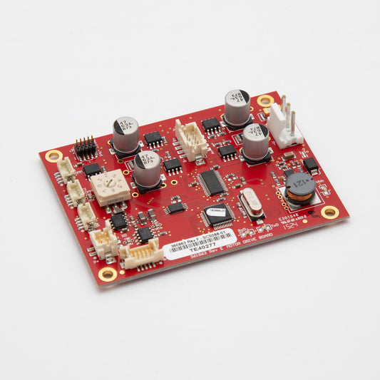 A red circuit board with a small electronic device mounted on it, showcasing intricate components.