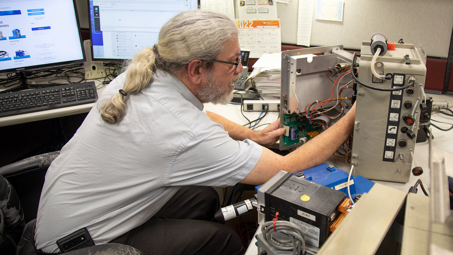 Person working on electronic equipment in a technical setting