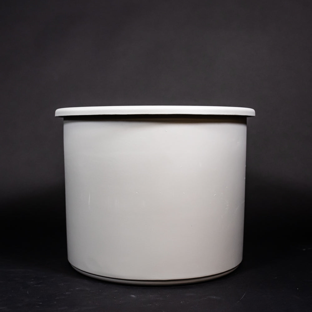 A grey plastic tub set against a dark black surface, highlighting its design and form.