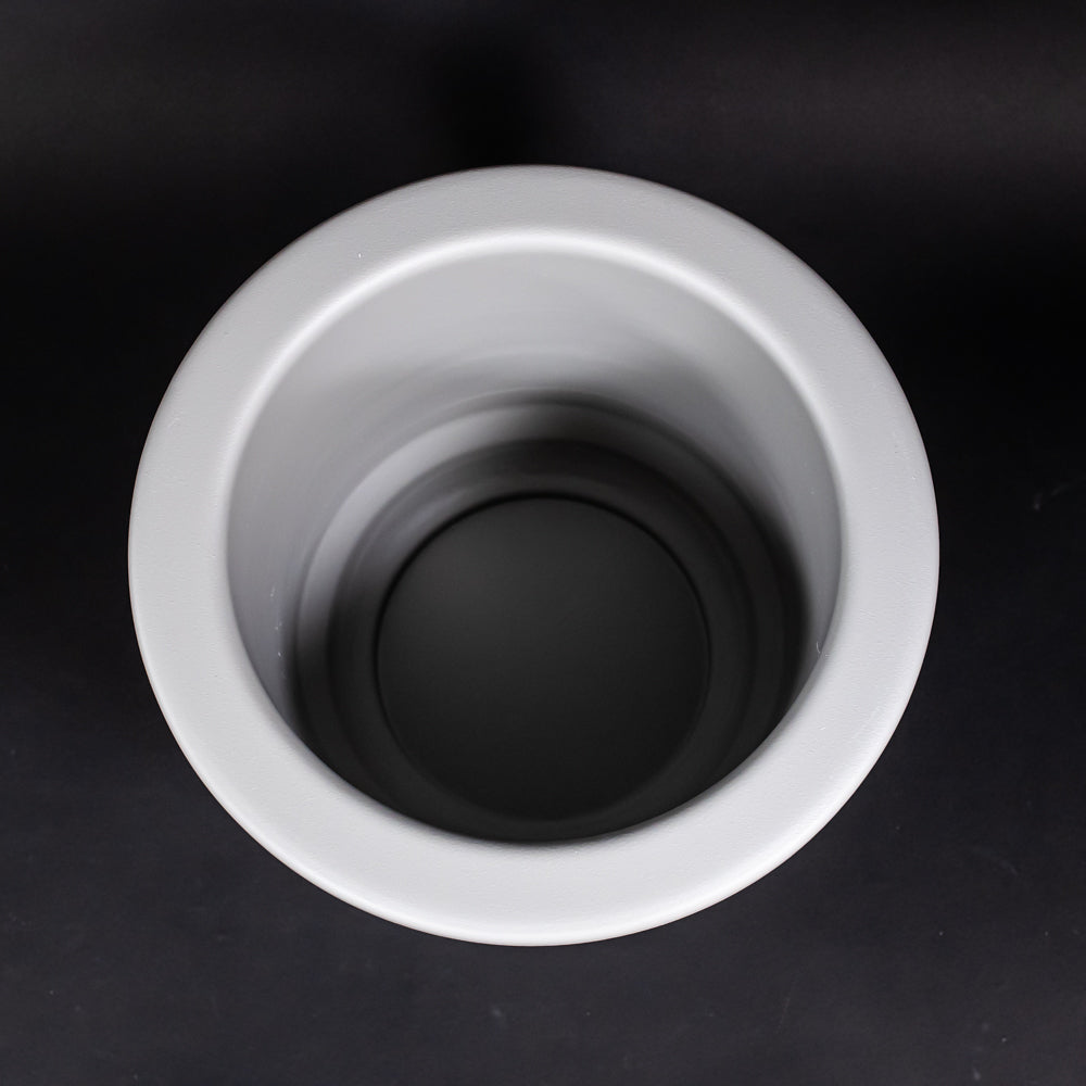 A grey plastic tub set against a dark black surface, highlighting its design and form.