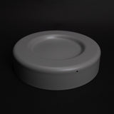 Round plastic tray with shallow recess for bottle placement