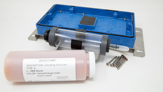 Plastic cover with mounting brackets, desiccant, and desiccant tube.