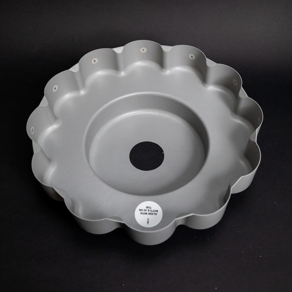 Round plastic tray with grooves for bottle placement
