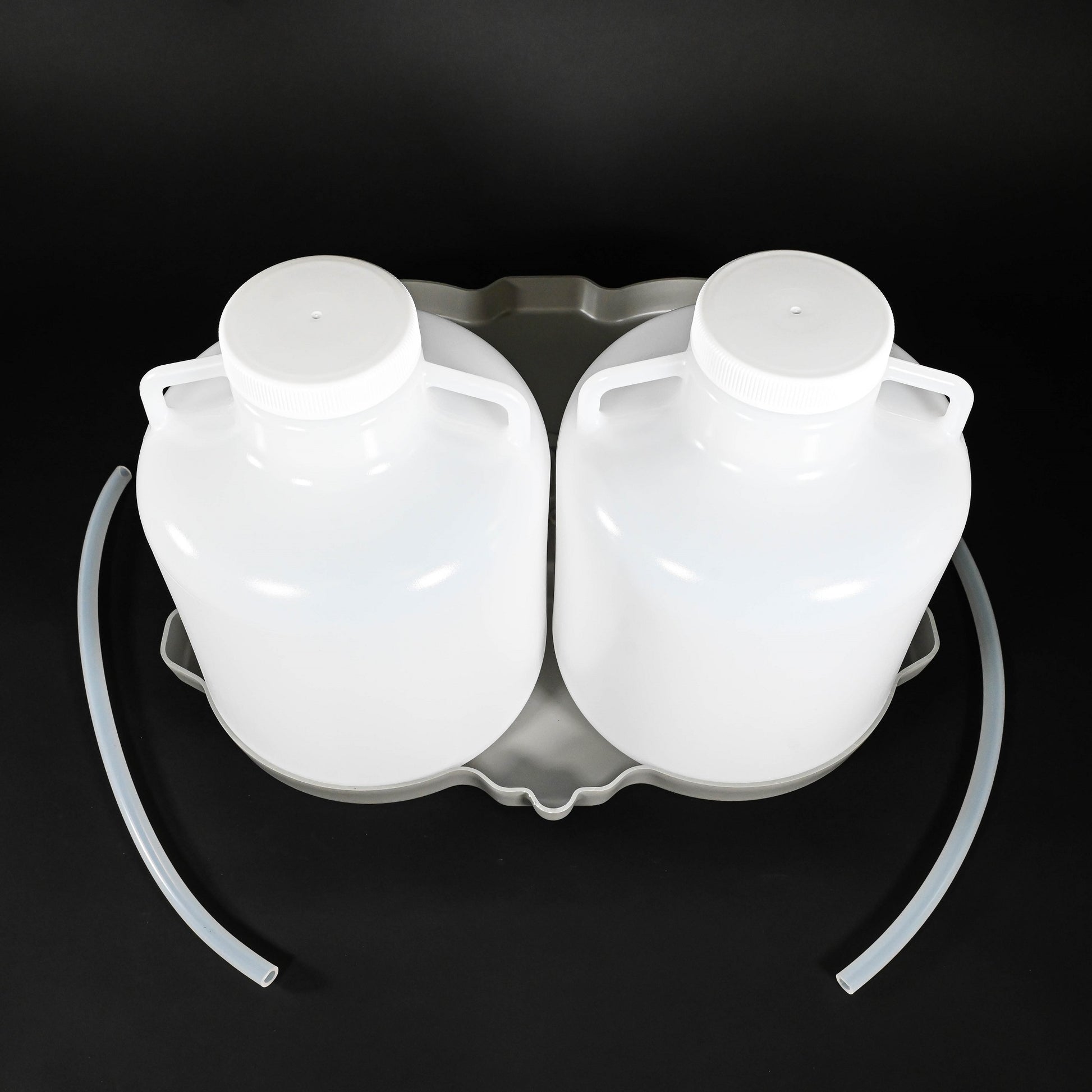 Two polyethylene bottles with caps, locating base and two discharge tubes.