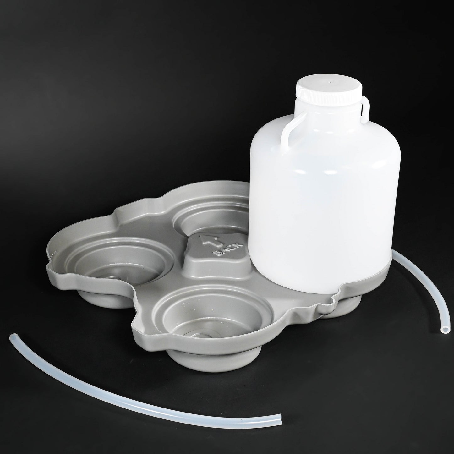 Polyethylene bottle with cap, locating base and two discharge tubes.