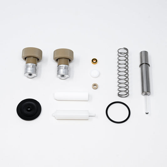 A collection of components for a pump, including various fittings and mechanical parts arranged neatly.