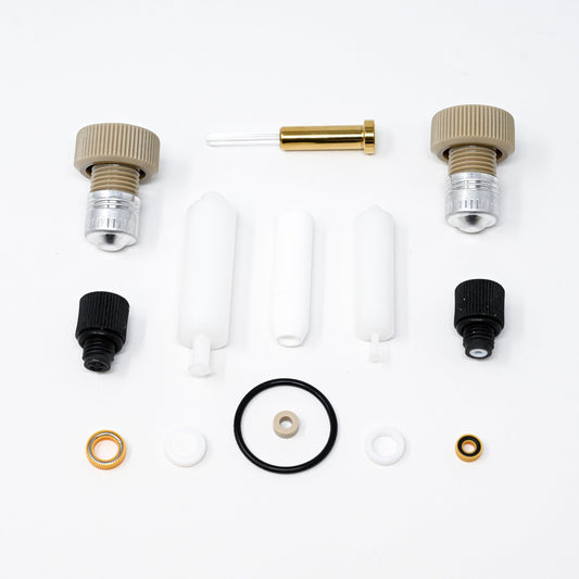 A collection of components for a pump, including various fittings and mechanical parts arranged neatly.