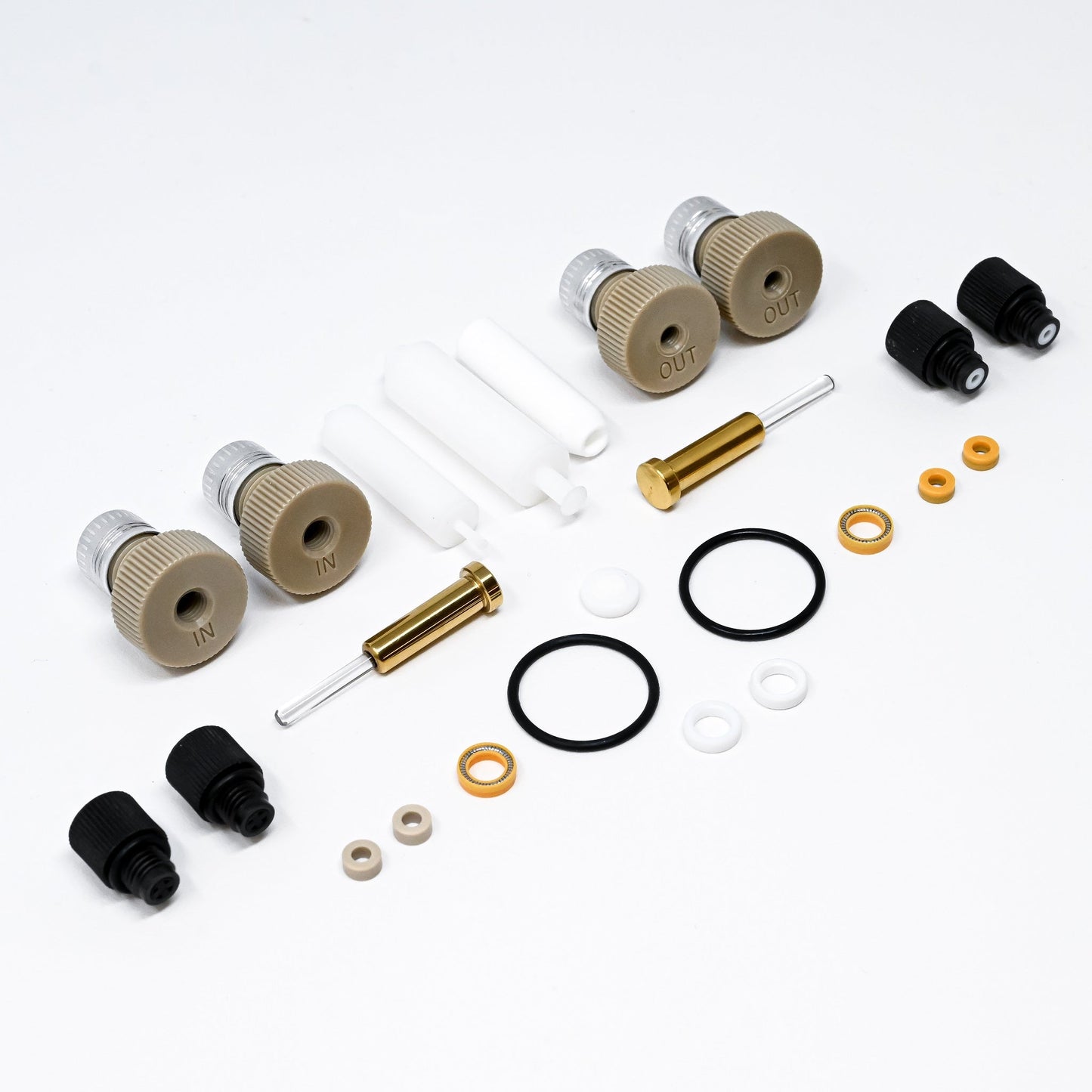 A collection of components for a pump, including various fittings and mechanical parts arranged neatly.