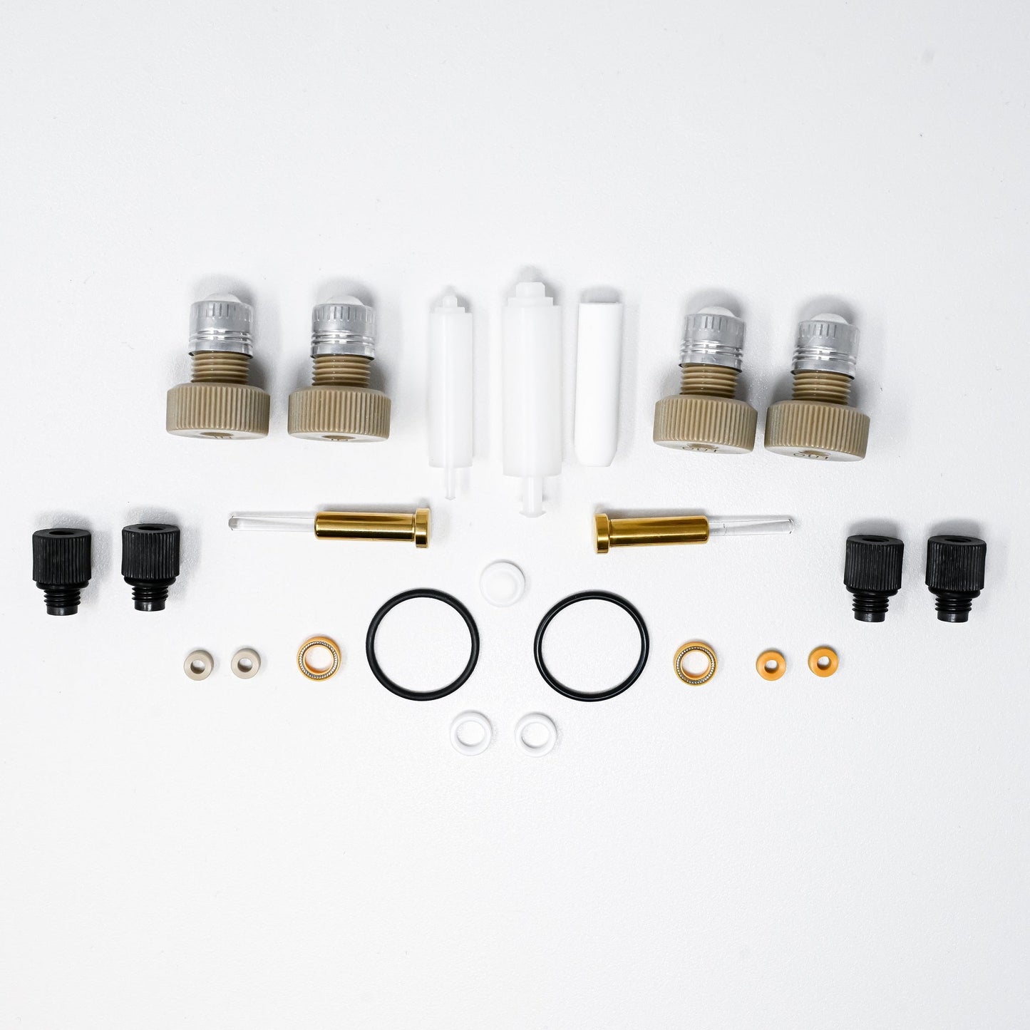 A collection of components for a pump, including various fittings and mechanical parts arranged neatly.