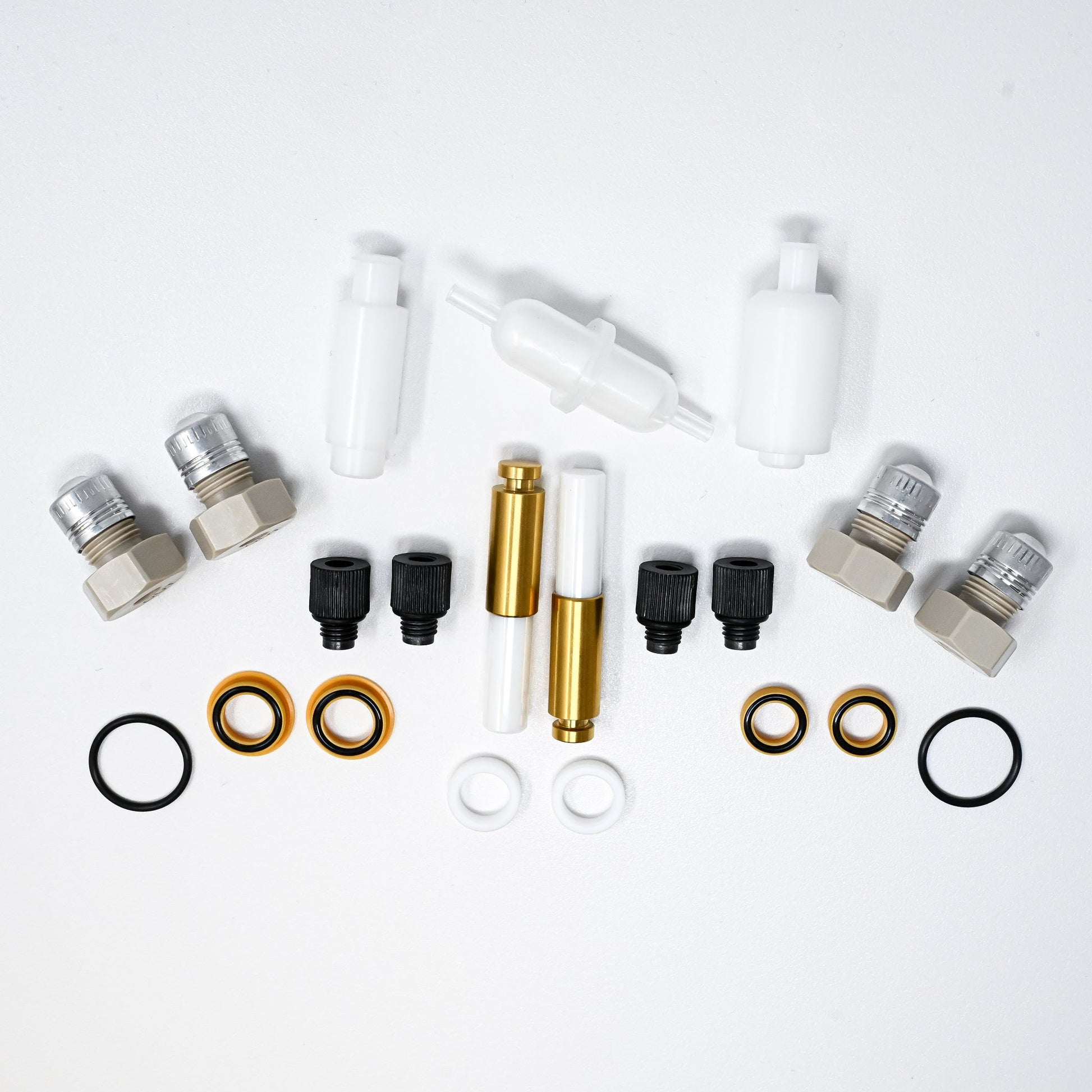 A collection of components for a pump, including various fittings and mechanical parts arranged neatly.