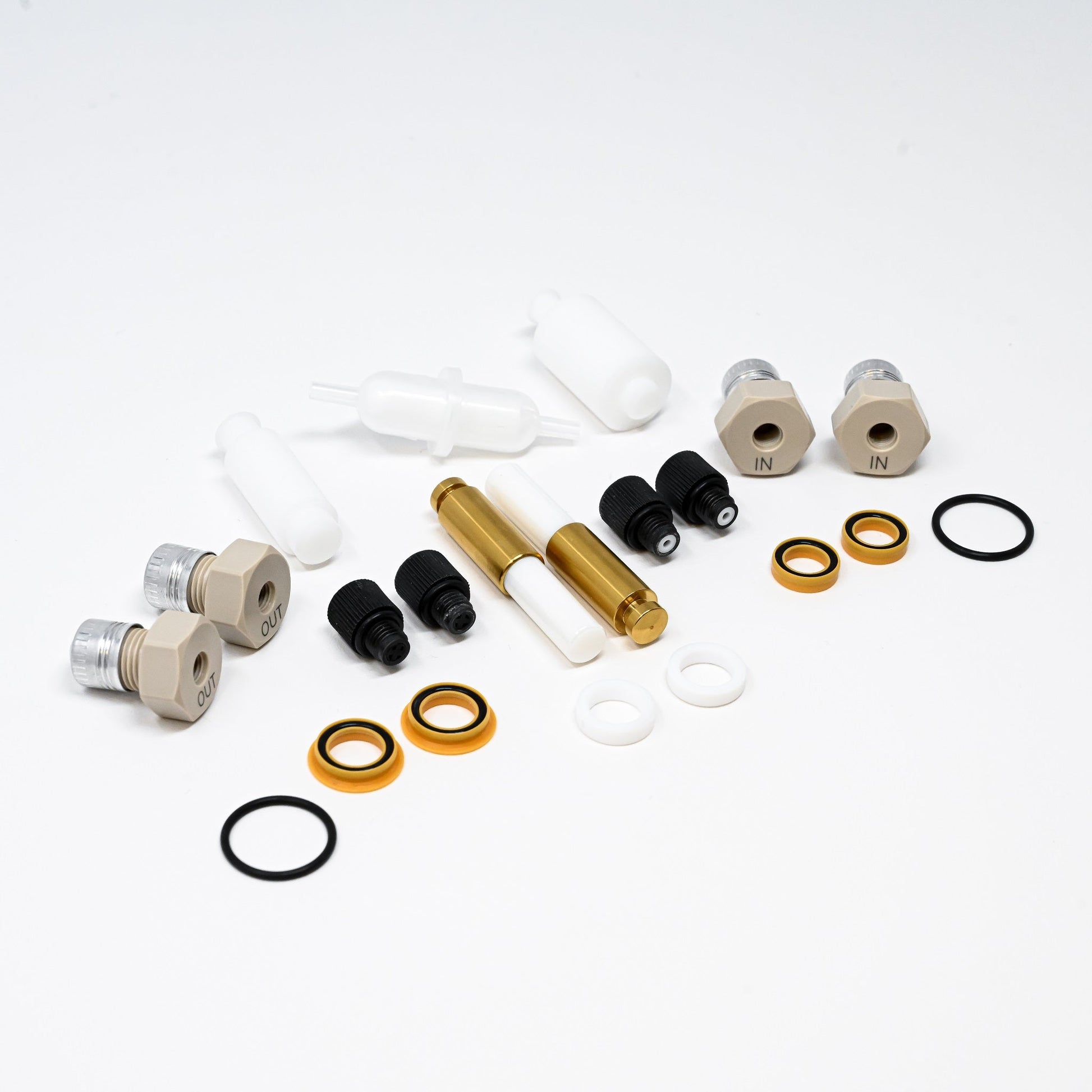 A collection of components for a pump, including various fittings and mechanical parts arranged neatly.