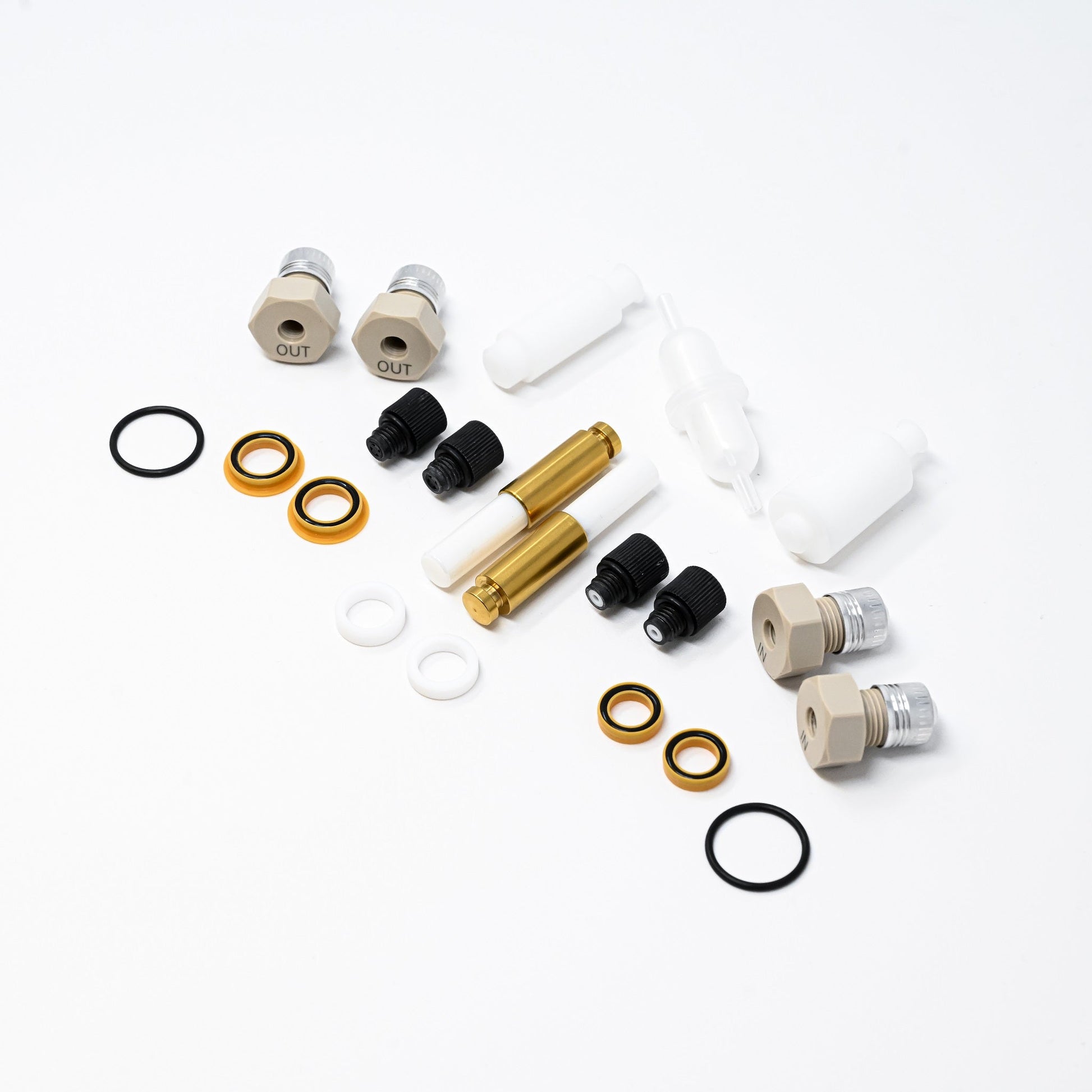 A collection of components for a pump, including various fittings and mechanical parts arranged neatly.