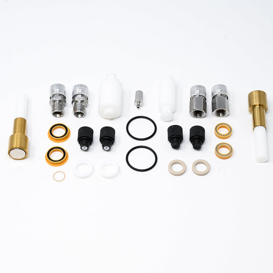 A collection of components for a pump, including various fittings and mechanical parts arranged neatly.