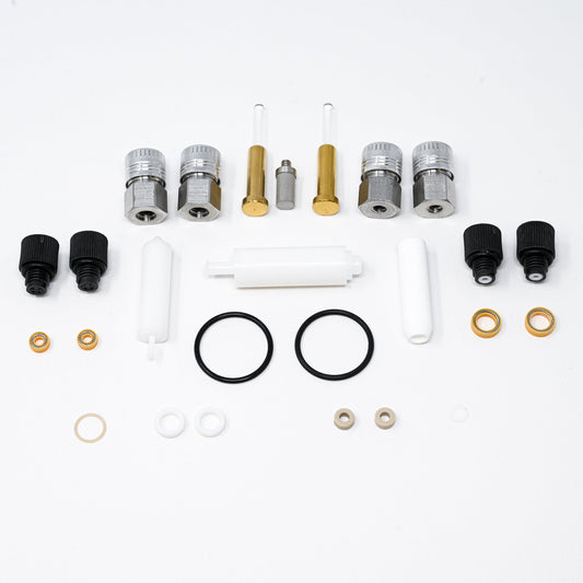 A collection of components for a pump, including various fittings and mechanical parts arranged neatly.