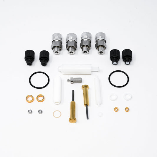 A collection of components for a pump, including various fittings and mechanical parts arranged neatly.